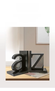 Detail of modern black a and Z letter bookends on a wooden desk with a minimalist style