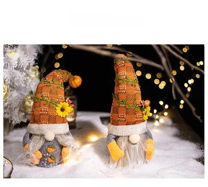 Close-up of autumn gnomes with orange plaid hats, sunflowers and pumpkin details