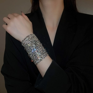 Macro shot of silver multilayer wide rhinestone stretch bracelet worn on model's wrist