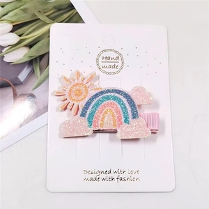 Sparkly rainbow and sun glitter hair clip for girls on white display card with pink ribbon clip