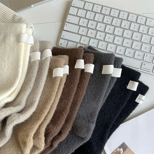 Detail of warm wool blend socks with HONEY label in various earthy tones and ribbed cuffs