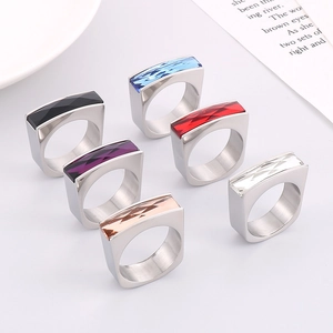 Detail view of colorful geometric faceted gemstones set in gold-tone brushed metal rings