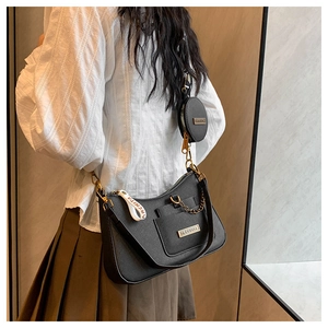 Detail of black lychee grain crossbody bag with mini pouch and gold chain strap
