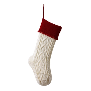 Knitted Christmas stocking in red and ivory white featuring heart-tassel and cable pattern