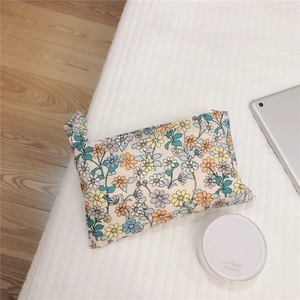 Detailed view of floral cotton storage pouch with daisy patterns and metal zipper closure