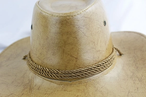 Détail d'un chapeau de cowboy en similicuir marron avec corde tressée et œillets