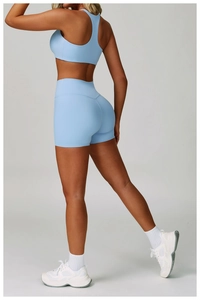 Dettaglio del set da yoga azzurro con reggiseno sportivo a vogatore e pantaloncini a vita alta