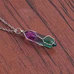 Macro detail of wire-wrapped purple and green gradient crystal pendant necklace