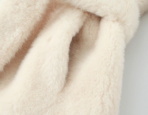 Macro detail of plush faux fur texture on a cream-colored fashionable women coat