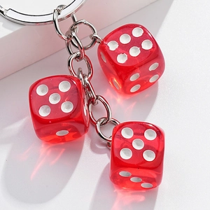 Three transparent red acrylic dice charms on a high-shine metal keychain with white dots