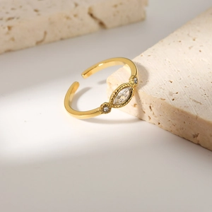 Golden vintage open ring with marquise-cut white zircon on a natural stone background