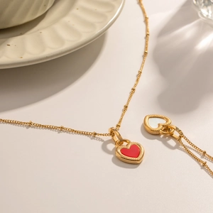 Detail of 18K gold stainless steel necklace featuring a double-sided red and white heart pendant