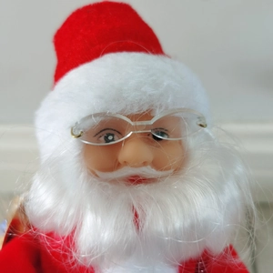 Close-up of 30cm musical Santa doll with plush red hat, white beard, and glasses details