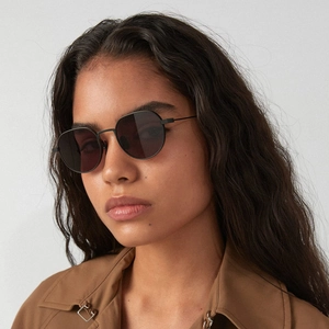 Classic retro sunglasses with black round frames on male model wearing a brown trench coat