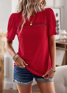 Detail of red crew neck t-shirt featuring hollow embroidery and lace patchwork fabric