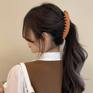 Matte brown twisted banana clip for high ponytail shown on model with elegant hairstyle