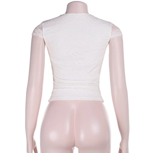 Vista posteriore dettagliata del top in pizzo bianco con intricati ricami floreali