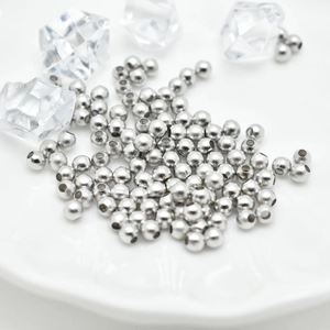 Polished silver metal spacer beads for jewelry making on a white plate with ice props