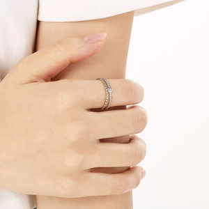 Detail of silver double-layered ring with dot texture and single cubic zirconia on finger