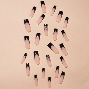 Uñas postizas extra largas estilo francés nude y negro con corazones de diamantes