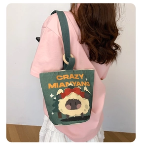 Detail of dark green canvas bucket bag featuring a cute sheep print and artistic text