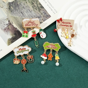 Detail of four colorful enamel Christmas pins with festive bells and snowman charms