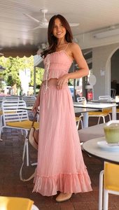 Detail of pink two-piece set featuring a drawstring top and pleated skirt in soft fabric