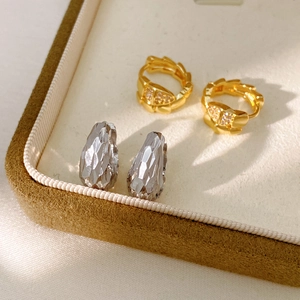 Detail of 14K gold plated zircon snake hoop and silver teardrop earrings in a jewelry box