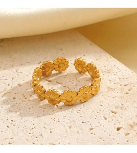 Macro shot of adjustable golden daisy ring with textured petals on a stone surface