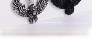 Macro detail of eagle pendants showing intricate feather textures in silver and matte black