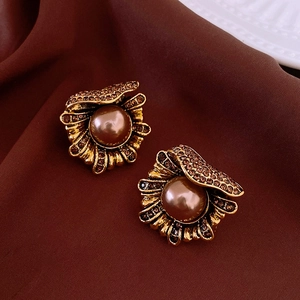 Detail of vintage gold fan earrings featuring a large brown pearl and crystal pave