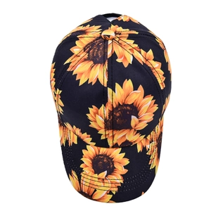 Close-up of a black baseball cap featuring vibrant yellow sunflower prints on high-quality fabric