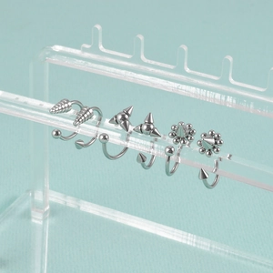 Punk style stainless steel horseshoe lip rings and nose studs set on acrylic display