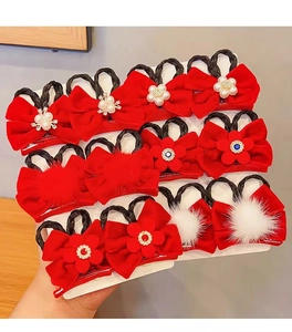 Detail of red bow hair clips with white pearls and floral accents on a display card