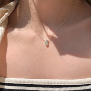 Macro detail of S925 sterling silver necklace with light blue round crystal on neck