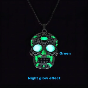 Detail showing the green night glow effect on a silver skull pendant with lotus carving