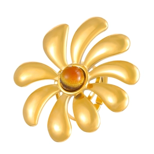 Detail shot of golden sunburst flower ring featuring a translucent amber center stone
