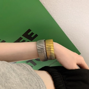 Bracciali rigidi larghi a costine in acciaio al titanio lucido oro e argento