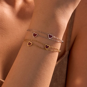 Elegant gold and silver double-layered heart charm bracelets shown on woman's wrist