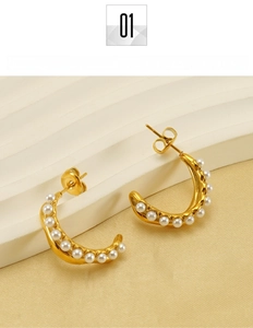 Close-up of 18K gold-plated C-shaped earrings featuring dainty white pearl inlays