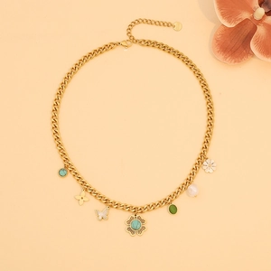 Gold floral butterfly necklace with heart pearls and turquoise charms on a soft backdrop