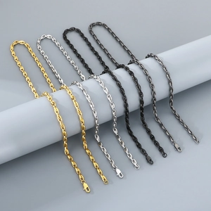 Close-up of minimalist oval link chain necklaces in gold, silver, black, and dark gray steel