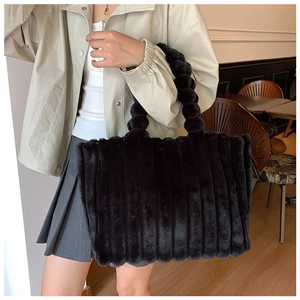 Close-up of black plush striped tote bag featuring unique bubble handle and soft texture