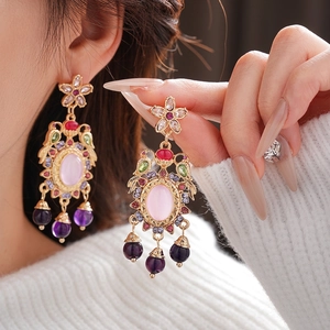 Vintage floral drop earrings with colorful crystals and purple bead tassels on model