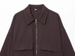 Détail de la veste zippée marron foncé avec poches de poitrine et étiquette de taille S