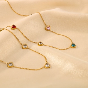 18K gold plated titanium necklace with colorful heart pendants on soft silk background