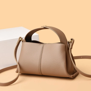 Brown litchi grain square handbag with handle and adjustable strap on beige background