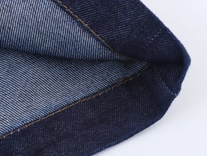 Detailaufnahme von dunkelblauem Twill-Denim mit gelben Kontrastnähten aus der Nähe
