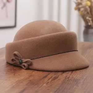 Elegant caramel wool felt equestrian hat with rhinestone bow detail in a cozy home setting