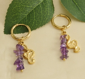 Macro detail of 18k gold musical note earrings with purple amethyst natural stones
